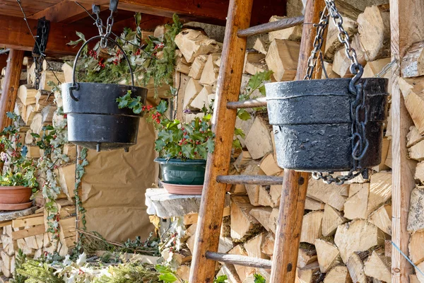 Wood logs rows with black cauldrons and ladder — Stock Photo, Image