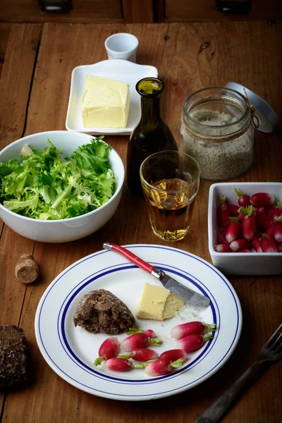 Plate with radish and butter on a table — Stock Photo, Image