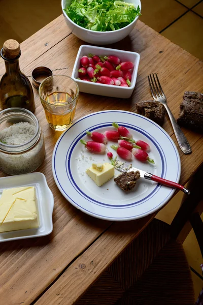 Plate with radish and butter on a table — Stock Photo, Image