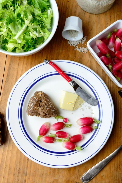 Assiette avec radis et beurre sur une table — Photo