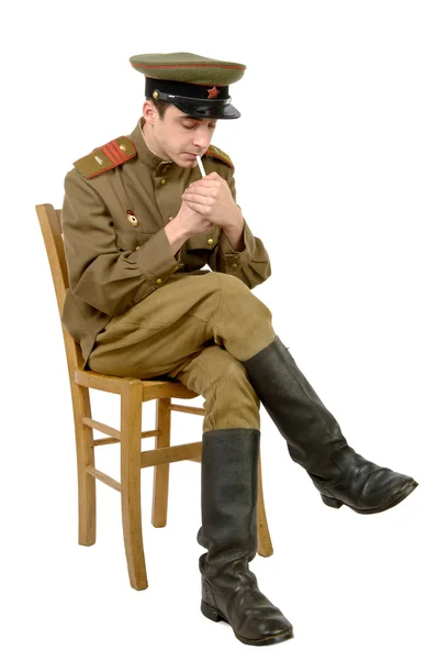 Un joven oficial soviético sentado en una silla fumando un cigarrillo —  Fotos de Stock