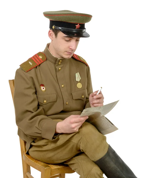 Un jeune officier soviétique assis sur une chaise a lu un journal — Photo