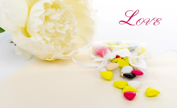Caramelo con una flor blanca puesta sobre una mesa — Foto de Stock