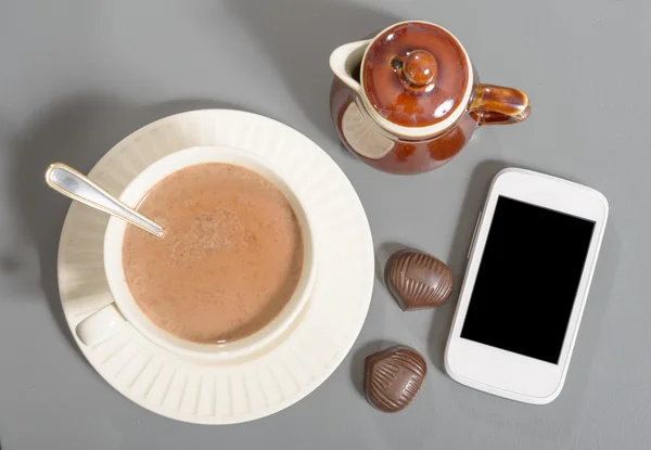 Xícara de chocolate quente com um telefone — Fotografia de Stock