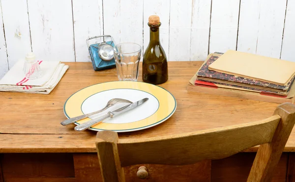 Plate and cutlery on an old wooden table — Stock Photo, Image