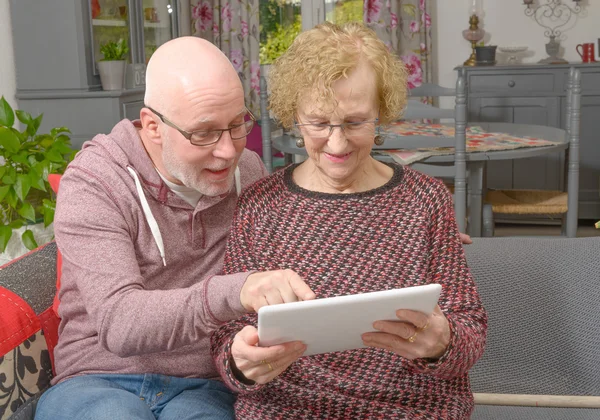 Matka i jej dorosły syn patrząc na cyfrowe tabletki — Zdjęcie stockowe