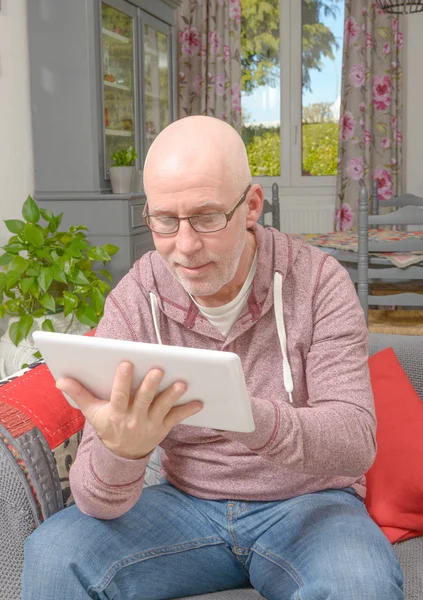 Un homme avec des lunettes regardant une tablette — Photo