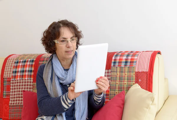 Una mujer de mediana edad mirando una tableta digital —  Fotos de Stock