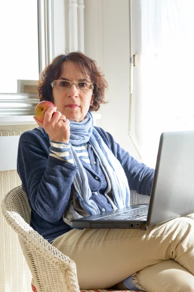 Una mujer mayor comiendo una manzana —  Fotos de Stock