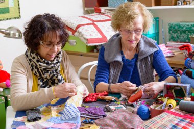 two women working on their quilting clipart