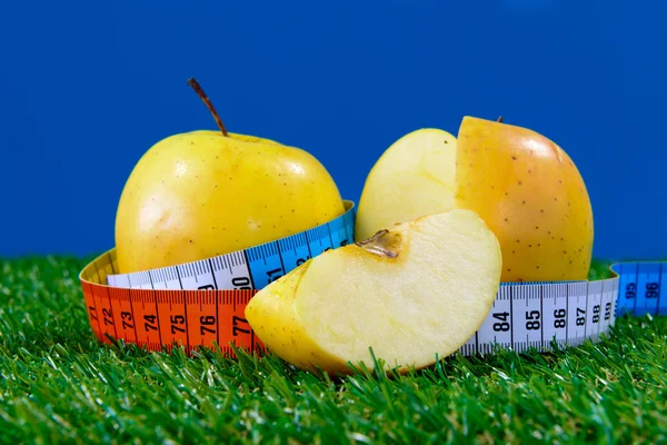 An apple surrounded by a measuring tape — Stock Photo, Image