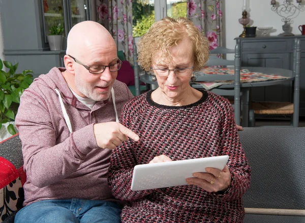 An elderly mother with her son watching tablet — Stock Photo, Image