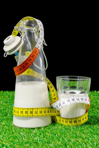 Bottle and glass of milk with a tape measure — Stock Photo, Image