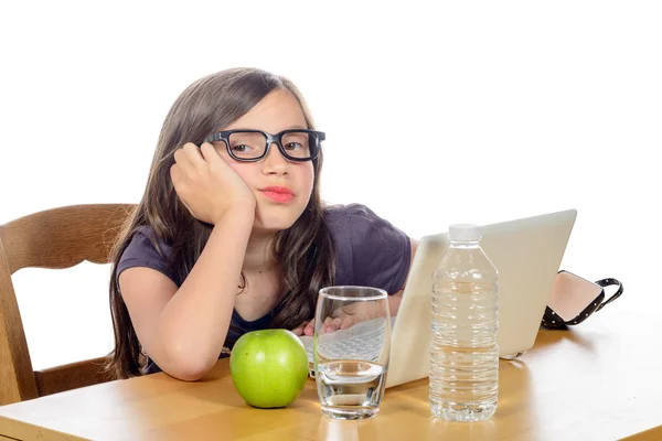 Una bambina stanca con il suo computer e una mela — Foto Stock