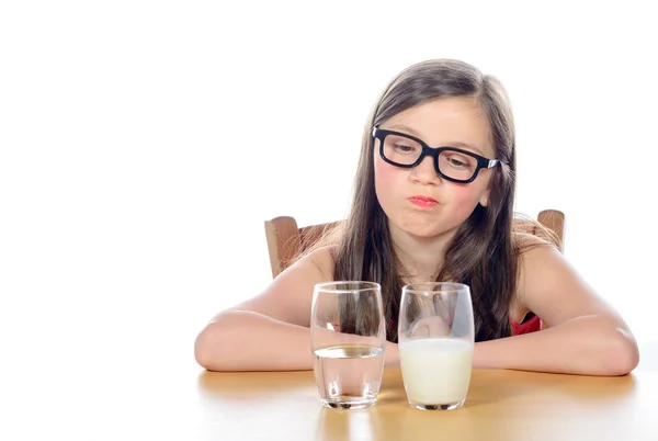 En liten flicka har ett val mellan vatten och mjölk — Stockfoto