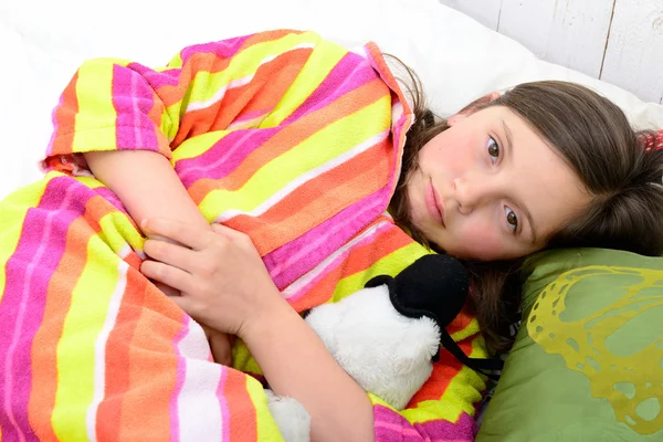 Uma menina em sua cama tem uma dor de estômago — Fotografia de Stock