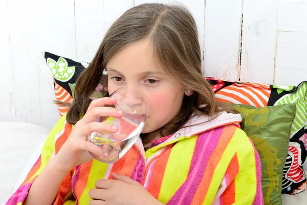 En sjuk tjej dricka ett glas vatten — Stockfoto