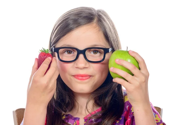 Una niña pequeña con una manzana y una fresa — Foto de Stock