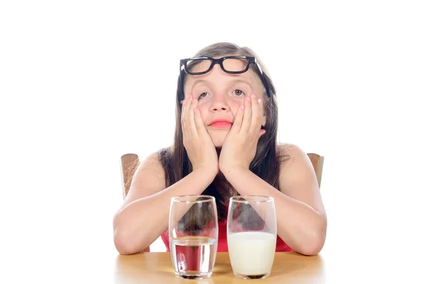 Een meisje heeft een keuze tussen water en melk — Stockfoto