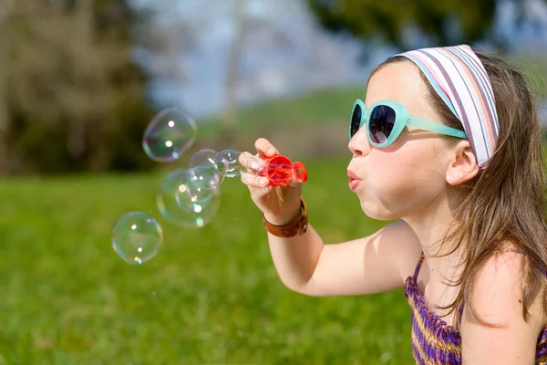 Een klein meisje maken zeepbellen — Stockfoto