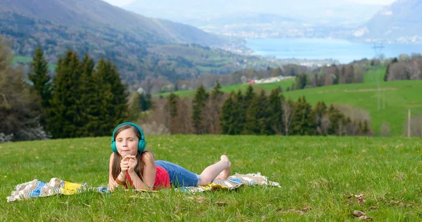 A pretty young girl listening to music in nature — Stock Photo, Image