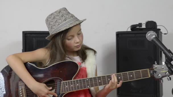 Ein hübsches kleines Mädchen, das Gitarre spielt — Stockvideo