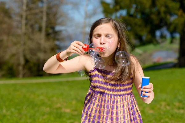 En liten flicka att göra såpbubblor — Stockfoto