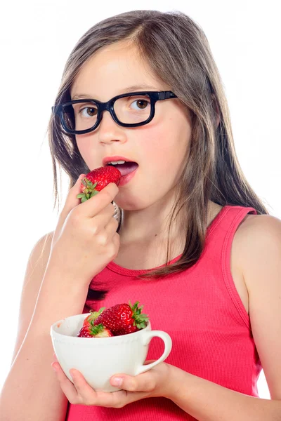 Een klein meisje eten van een aardbei — Stockfoto