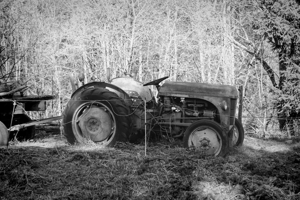 Um velho tractor abandonado num campo — Fotografia de Stock