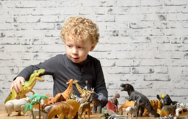 Ett litet barn leker med leksaker djur — Stockfoto