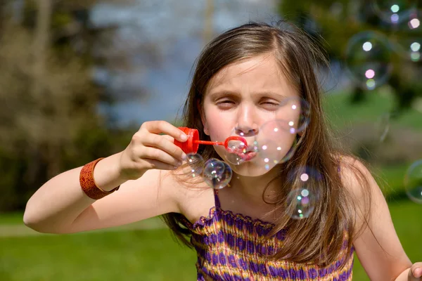 Ein kleines Mädchen, das Seifenblasen macht — Stockfoto