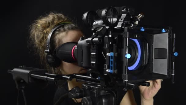 Mujer bonita con una cámara de cine profesional — Vídeos de Stock