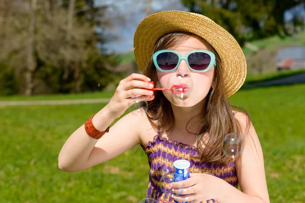 En liten flicka att göra såpbubblor — Stockfoto