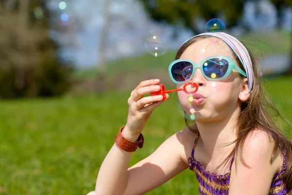 Una niña haciendo burbujas de jabón — Foto de Stock