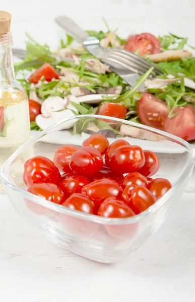 Petites tomates dans un bocal en verre avec salade de saison — Photo