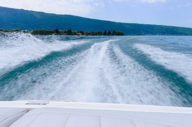 dalgaları arkasında bir motorlu tekne