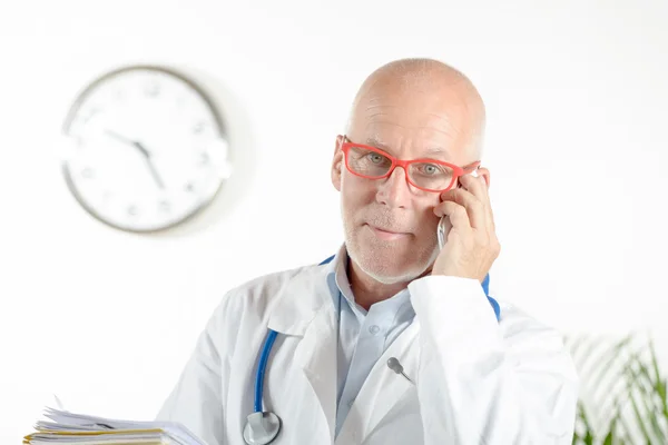 Un médico con teléfono en su consultorio —  Fotos de Stock