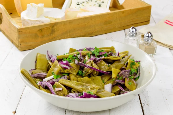 Plate of fresh green beans and red onions — Stock Photo, Image