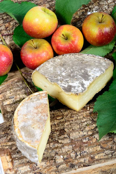 Französischer Käse mit Äpfeln im Hintergrund — Stockfoto