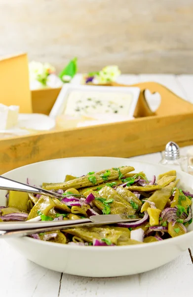 Plate of fresh green beans and red onions — Stock Photo, Image