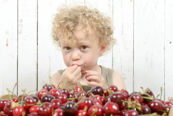 Malý Plavovlasý chlapec jíst třešně — Stock fotografie