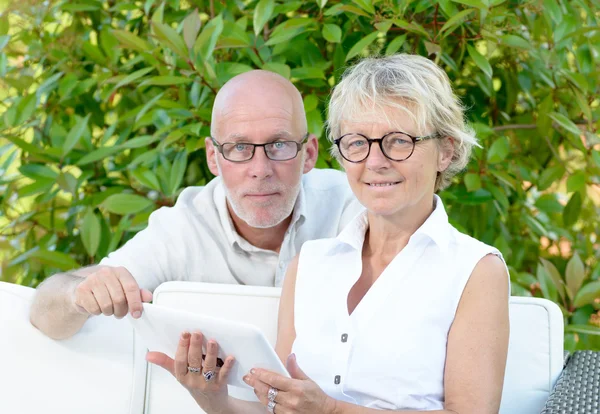 Ένα ζευγάρι των πρεσβυτέρων κοιτάζοντας ψηφιακή δισκίο — Φωτογραφία Αρχείου