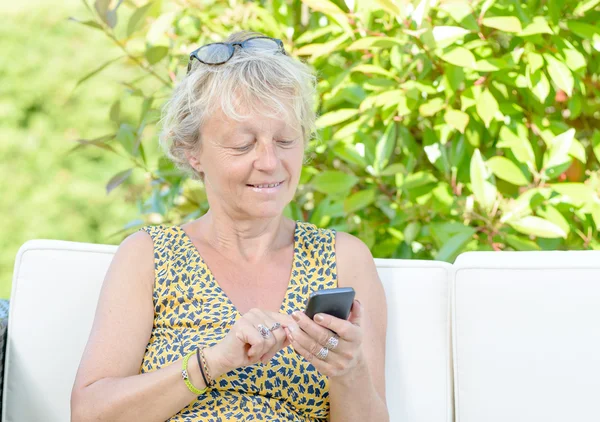 Portrait of a beautiful middle-aged woman on phone outside — Stock Photo, Image