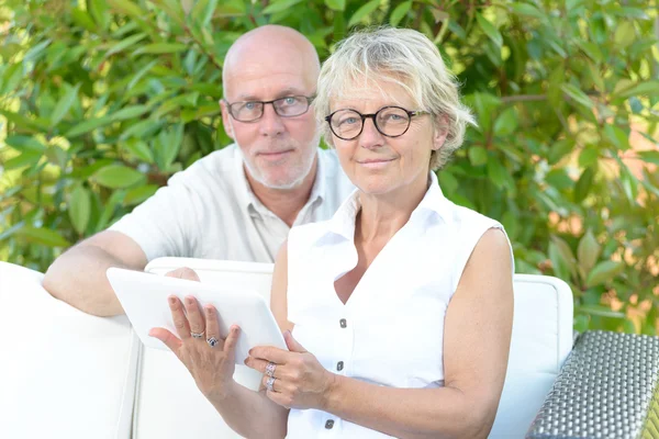 A couple of seniors look at a digital tablet — Stock Photo, Image