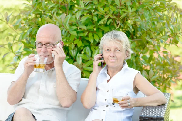 A couple sitting each with a phone — Stock Photo, Image