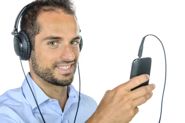 Молодой человек слушает музыку со своего телефона — стоковое фото