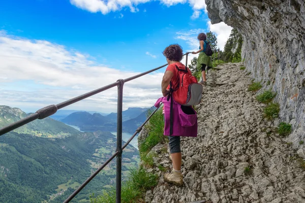 Two women hikers walking in the mountains — Stockfoto