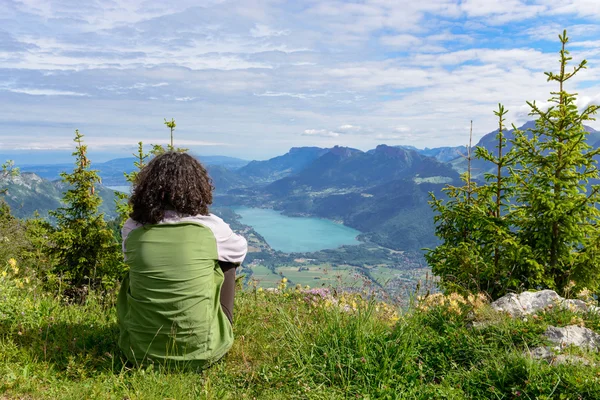 Woman sitting on cliff and  looking at landscape — Stok fotoğraf