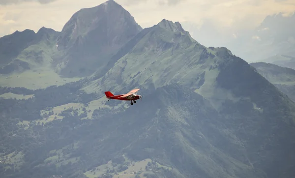 Um pequeno avião vermelho sobrevoando os Alpes franceses — Fotografia de Stock