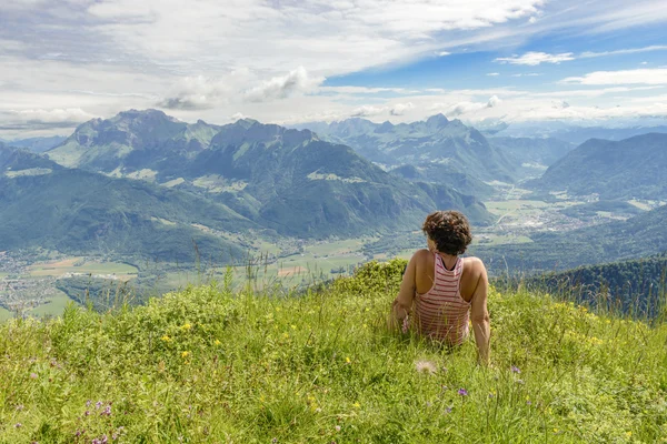 Woman sitting on cliff and  looking at landscape — Stok fotoğraf